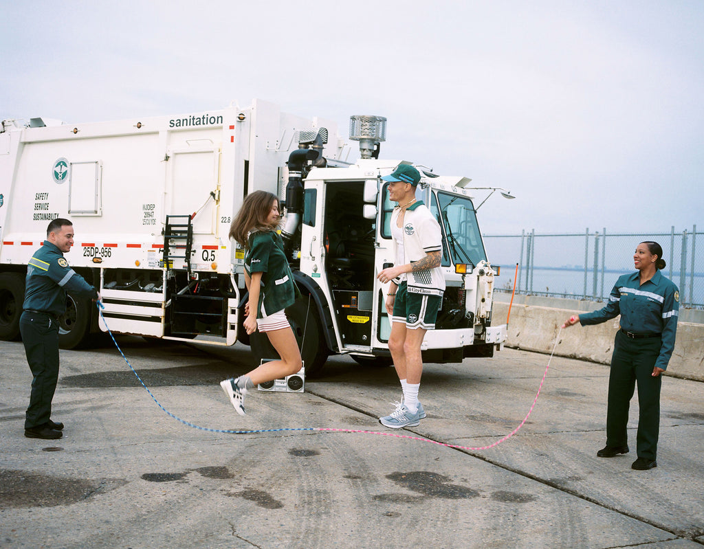 A male and female model jump roping with DSNY workers