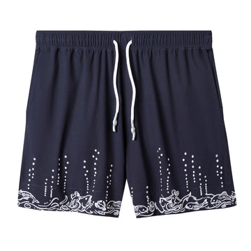 front lay flat product photo of swim trunks in navy with bubbly, fishy embroidery along the bottom hem slowly bubbling up the legs