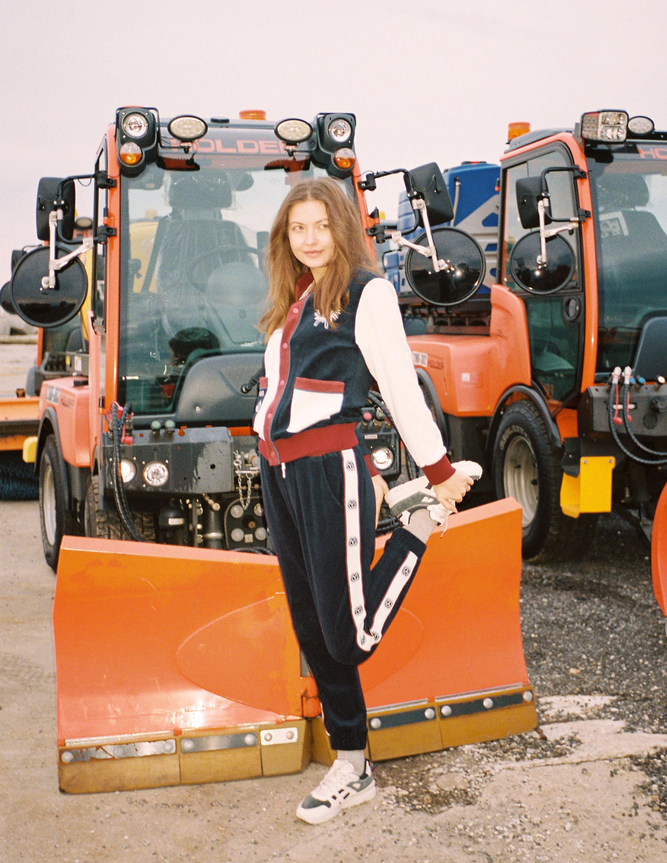 Female model stretching in set in front of snow plow