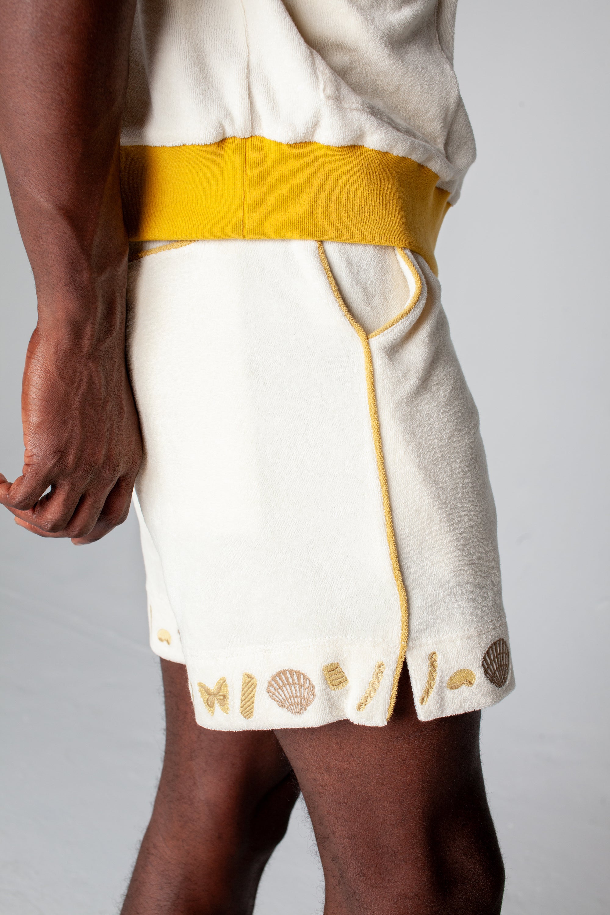 Side close up of man wearing vongole shorts with waistband of matching shirt showing