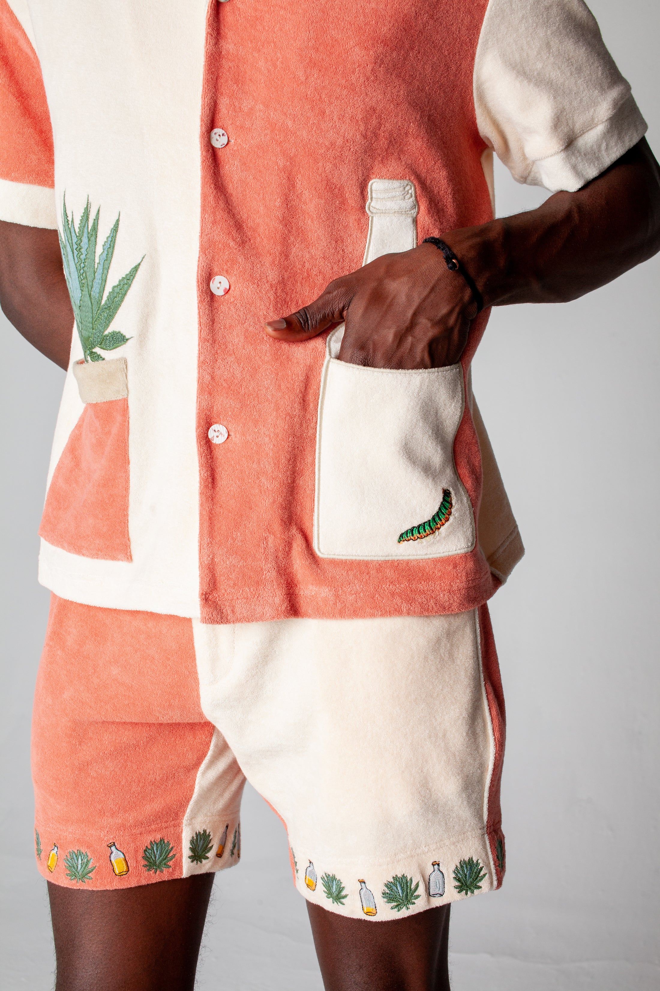 Close up of the male model wearing the full Gusanito set with his hand in the front pocket