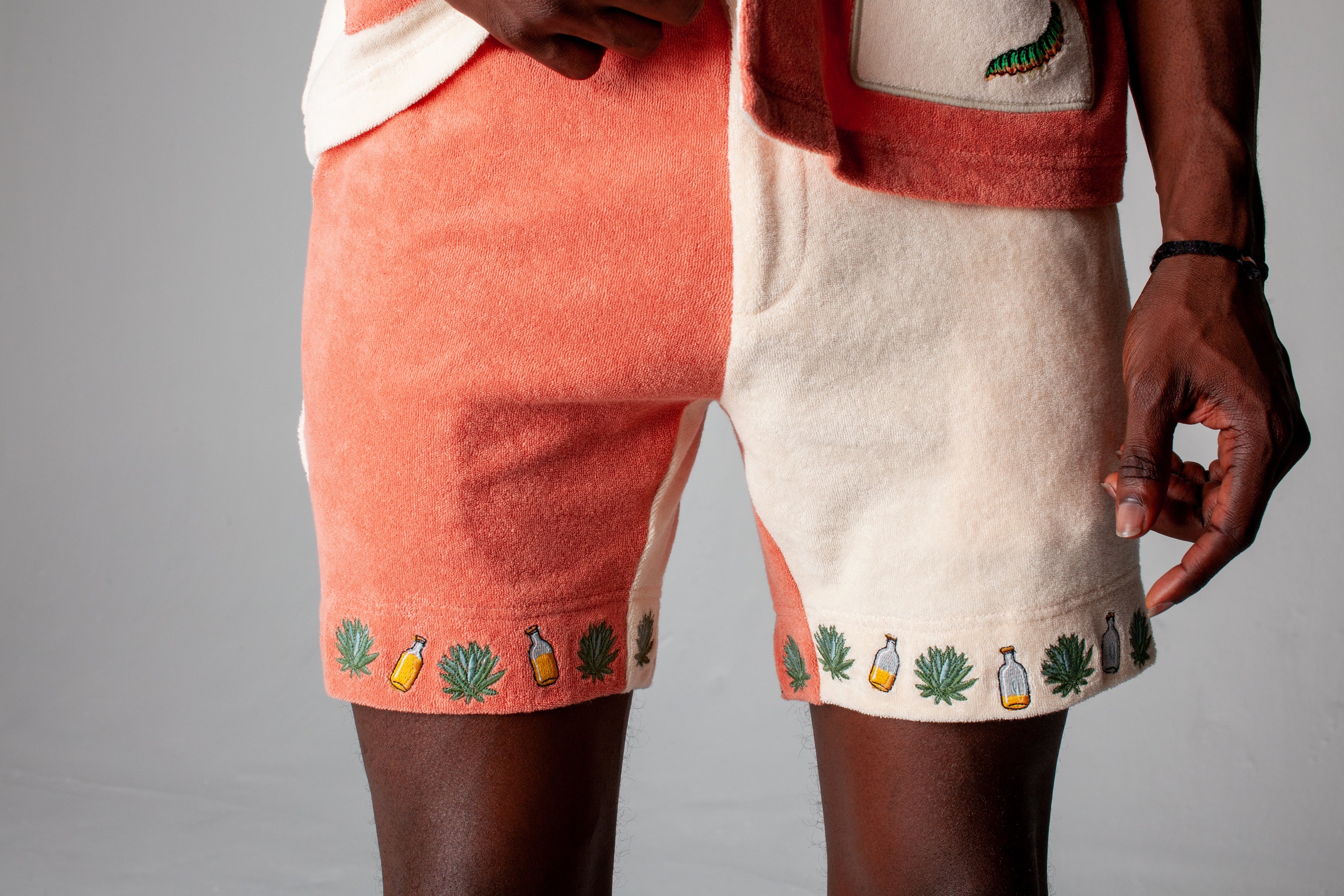 Close-up shot of a male model wearing the Gusanito shorts and top