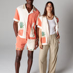 Male model wearing full Gusanito set standing next to a female model wearing the Gusanito top unbuttoned over a white tank top, showcasing the unisex style