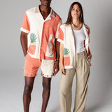 Male model wearing full Gusanito set standing next to a female model wearing the Gusanito top unbuttoned over a white tank top, showcasing the unisex style