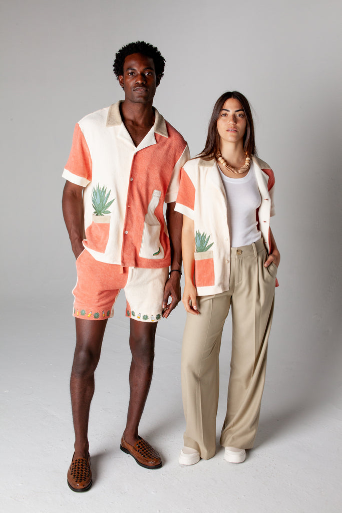 Male model wearing full Gusanito set standing next to a female model wearing the Gusanito top unbuttoned over a white tank top, showcasing the unisex style