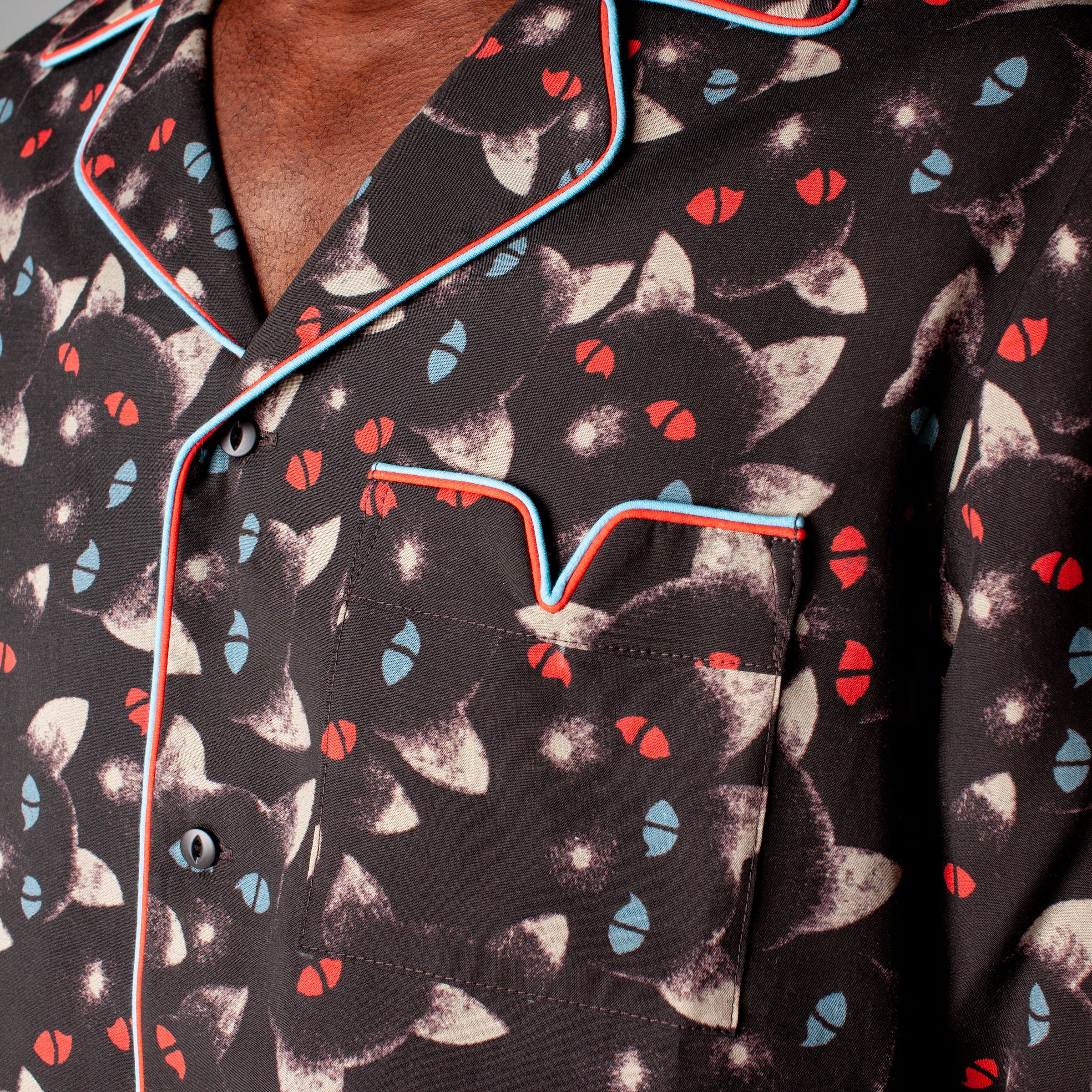 Close up of shirt collar and pocket with red and blue piping