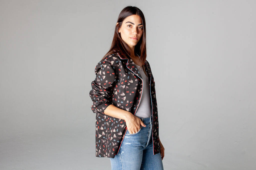 Female model in shirt unbuttoned over a white tank and blue jeans