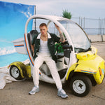 Male model sitting in sanitation car in DSNY shirt