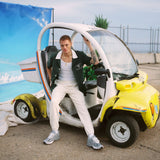 Male model sitting in sanitation car in DSNY shirt