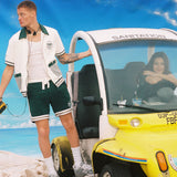 Man holds onto outside of DSNY car as woman stares at camera from driver's seat