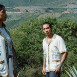 Man standing on hilltop wearing Alexis Zambrano shirt